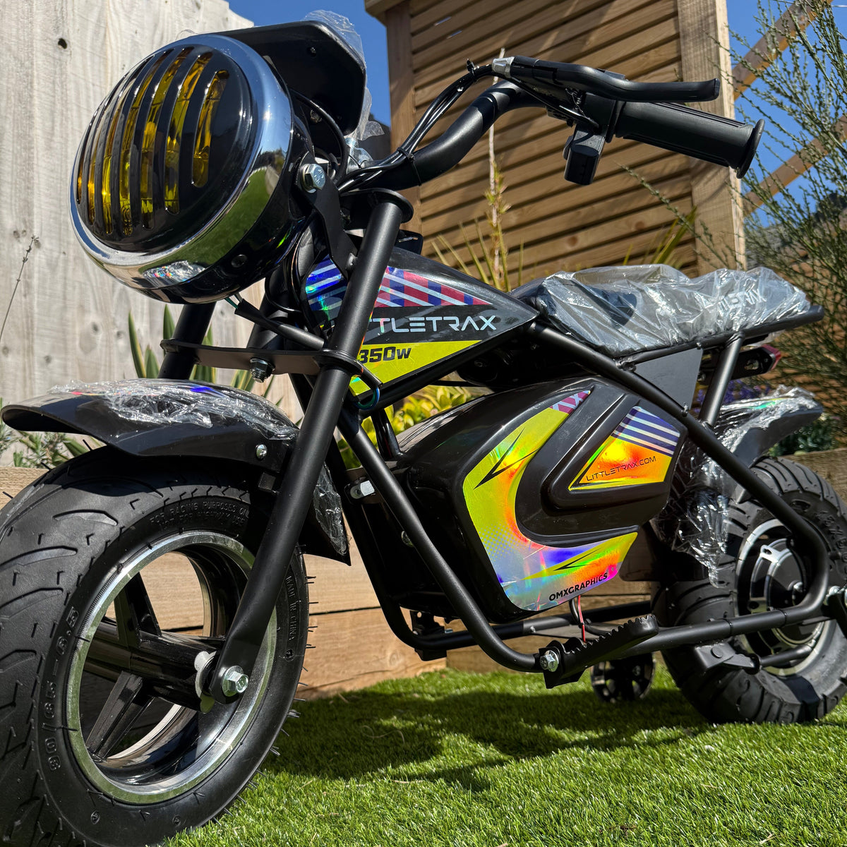 Small electric bike with colorful design on a wooden deck and grass background