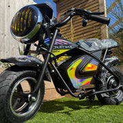 Small electric bike with colorful design on a wooden deck and grass background